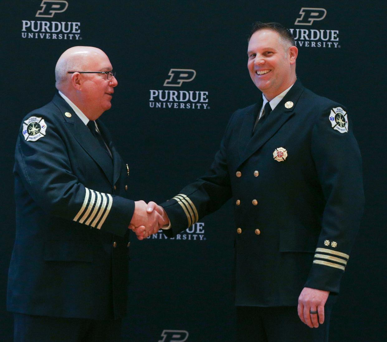 Purdue University Fire Department Retired Fire Chief, Kevin Ply, and incoming Fire Chief, Brad Anderson, pose for a photo after the changing of the guard ceremony, on Wednesday, Dec. 14, 2022, in Lafayette, Ind.