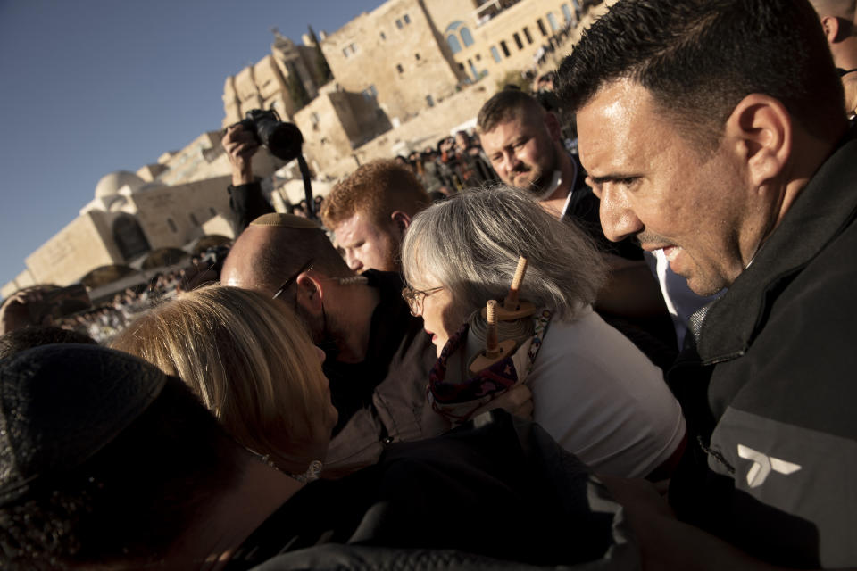 Members of the Women of the Wall clutch a Torah scroll as they are surrounded by Israeli security forces at the Western Wall, the holiest site where Jews can pray, in the Old City of Jerusalem, Friday, Nov. 5, 2021. Thousands of ultra-Orthodox Jews gathered at the site to protest against the Jewish women's group that holds monthly prayers there in a long-running campaign for gender equality at the site. (AP Photo/Maya Alleruzzo)
