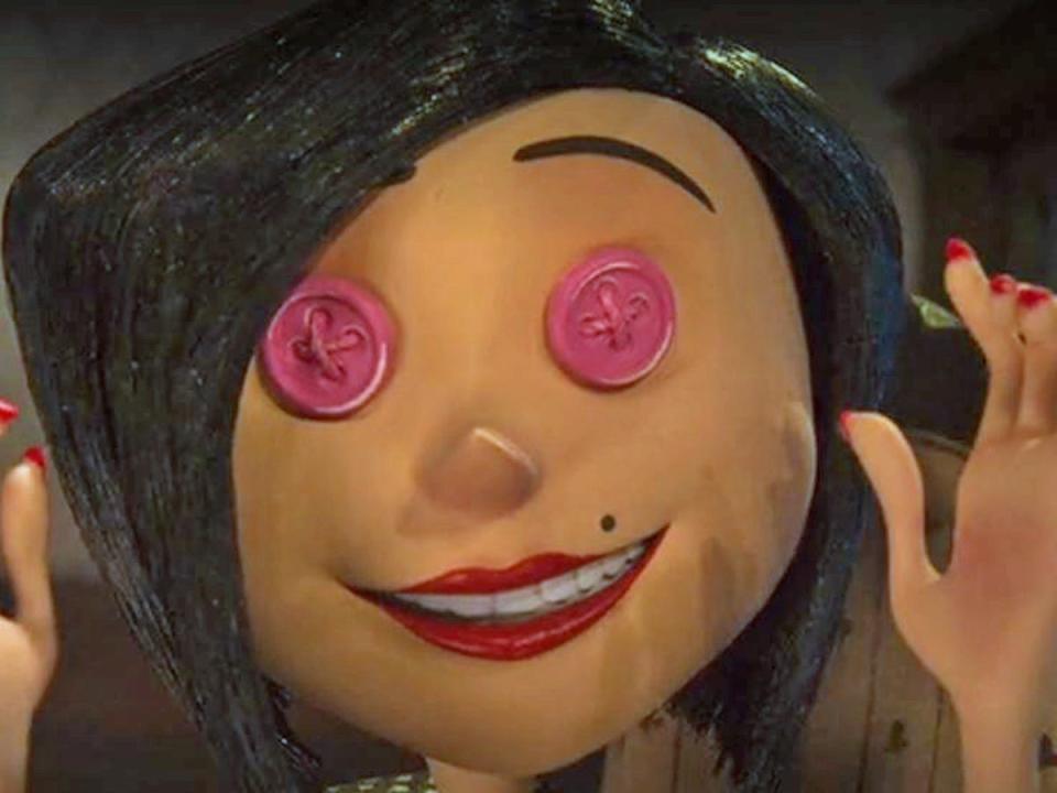 Coraline's other mother wearing pink button eyes in "Coraline" (2009).