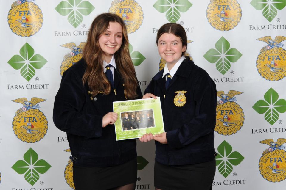 Mount Pulaski FFA members Grace Davis and Hannah Stoll accept the Foundation $3,000 Club Award at the Illinois State FFA Convention.