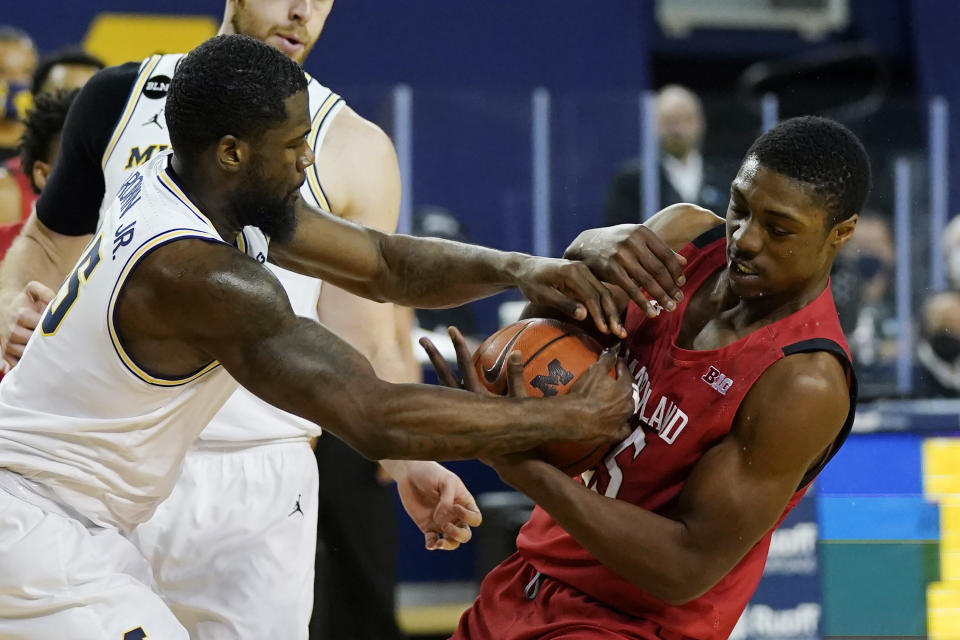 Michigan guard Chaundee Brown (15) and Maryland forward Jairus Hamilton (25) try controlling the ball during the first half of an NCAA college basketball game, Tuesday, Jan. 19, 2021, in Ann Arbor, Mich. (AP Photo/Carlos Osorio)