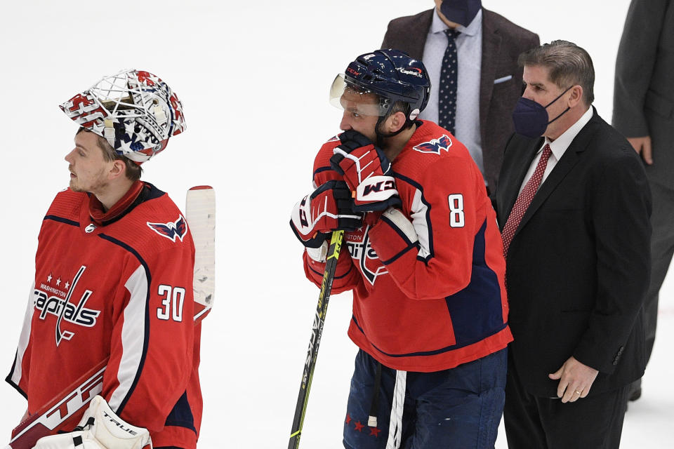 Washington Capitals left wing Alex Ovechkin (8), goaltender Ilya Samsonov (30) and head coach Peter Laviolette stand in the handshake line after Game 5 of an NHL hockey Stanley Cup first-round playoff series against the Boston Bruins, Sunday, May 23, 2021, in Washington. The Bruins won 3-1. (AP Photo/Nick Wass)