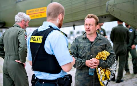 Peter Madsen (R), builder and captain of the private submarine "UC3 Nautilus" talks to a police officer in Dragoer Harbor south of Copenhagen on Friday, August 11 - Credit: BAX LINDHARDT/AFP/Getty Images