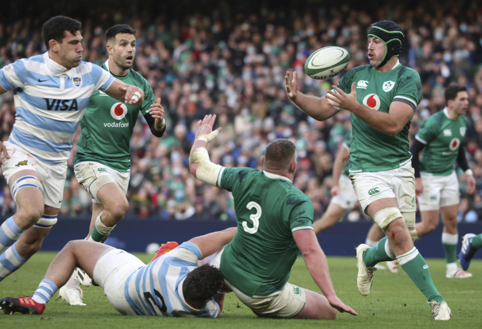 Ireland's Jack Conan, right, catches a pass from teammate Tadhg Furlong, middle, tacked by Argentina's captain Julian Montoya during the rugby union international match between Ireland and Argentina at the Aviva Stadium in Dublin, Ireland, Sunday, Nov. 21, 2021. (AP Photo/Peter Morrison)