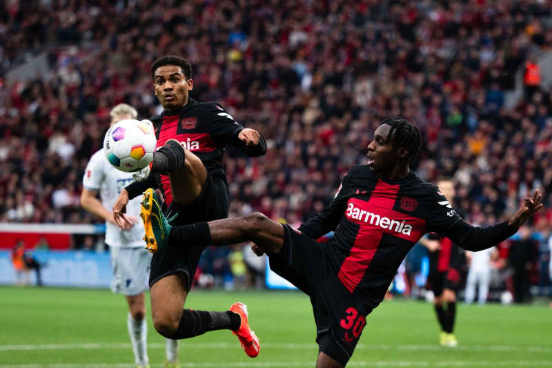 Leverkusen's Amine Adli (L) and Jeremie Frimpong in action during the German Bundesliga soccer match between Bayer Leverkusen and TSG 1899 Hoffenheim at BayArena. Marius Becker/dpa