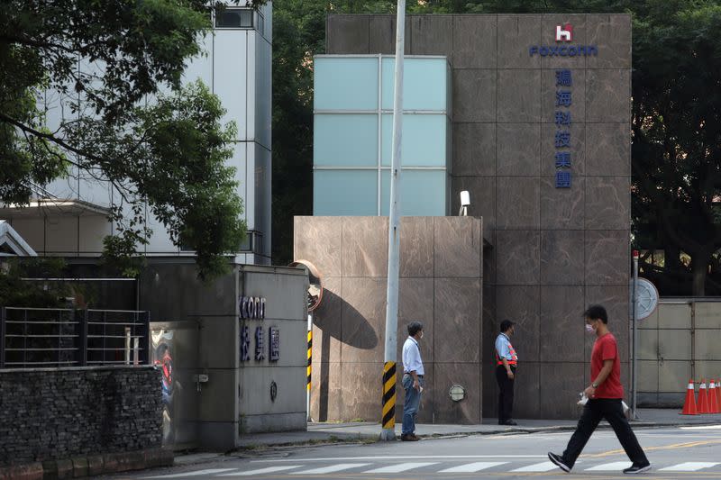 People wear masks to protect themselves from the coronavirus disease (COVID-19) while passing a Foxconn office building in Taipei