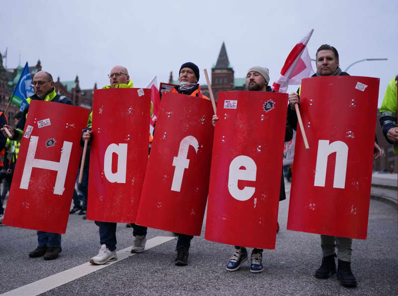 People take part in a demonstration in the Speicherstadt called by The Verdi trade union against the sale of shares in Hamburger Hafen und Logistik AG (HHLA) to the Italian shipping company MSC. Marcus Brandt/dpa