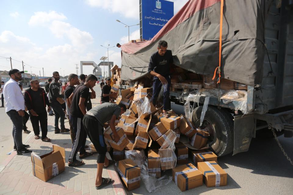 救援卡車2日從拉法關卡進入加薩後，巴勒斯坦民眾爭取物資。美聯社