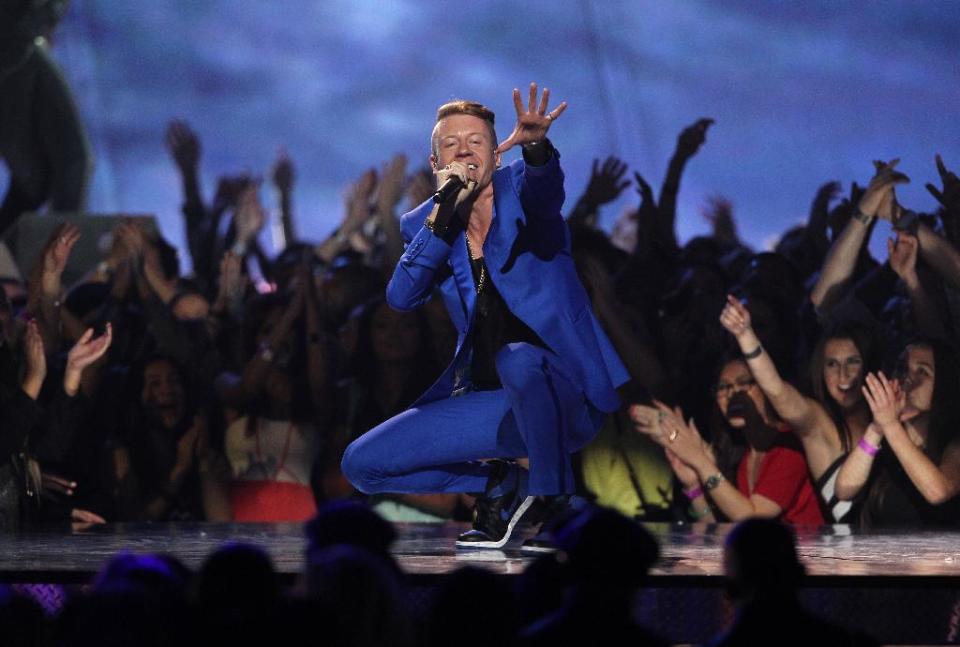 FILE - In this April 14, 2013 file photo, Macklemore performs "Can't Hold Us" at the MTV Movie Awards in Sony Pictures Studio Lot in Culver City, Calif. Macklemore & Ryan Lewis are top contenders at the Jan. 26, 2014, Grammy Awards, with seven nominations, including best new artist and song of the year for “Same Love.” Their debut album, “The Heist,” is up for album of the year and best rap album, while the massive hit “Thrift Shop” is nominated for best rap song and rap performance. The duo’s other hit, “Can’t Hold Us,” will compete for best music video. (Photo by Matt Sayles/Invision /AP)