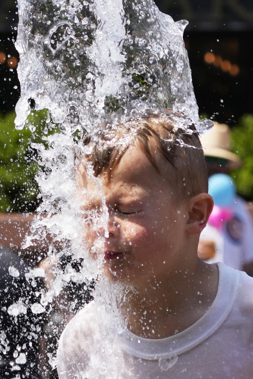 A boy cools off at a fountain during hot weather in Chicago, Sunday, June 16, 2024. (AP Photo/Nam Y. Huh)