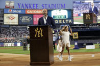 Baseball Hall of Famer Derek Jeter speaks as his daughter Bella Raine jumps by his side during a ceremony honoring his Hall of Fame induction, before a baseball game between the Tampa Bay Rays and the New York Yankees on Friday, Sept. 9, 2022, in New York. (AP Photo/Adam Hunger)