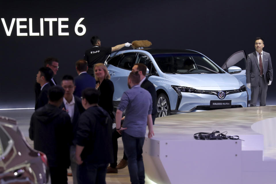 A worker dusts off the roof of the Velite 6, Buick's first all-electric model for China during the Auto Shanghai 2019 show in Shanghai on Tuesday, April 16, 2019. Automakers are showcasing electric SUVs and sedans with more driving range and luxury features at the Shanghai auto show, trying to appeal to Chinese buyers in their biggest market as Beijing slashes subsidies that have propelled demand. (AP Photo/Ng Han Guan)