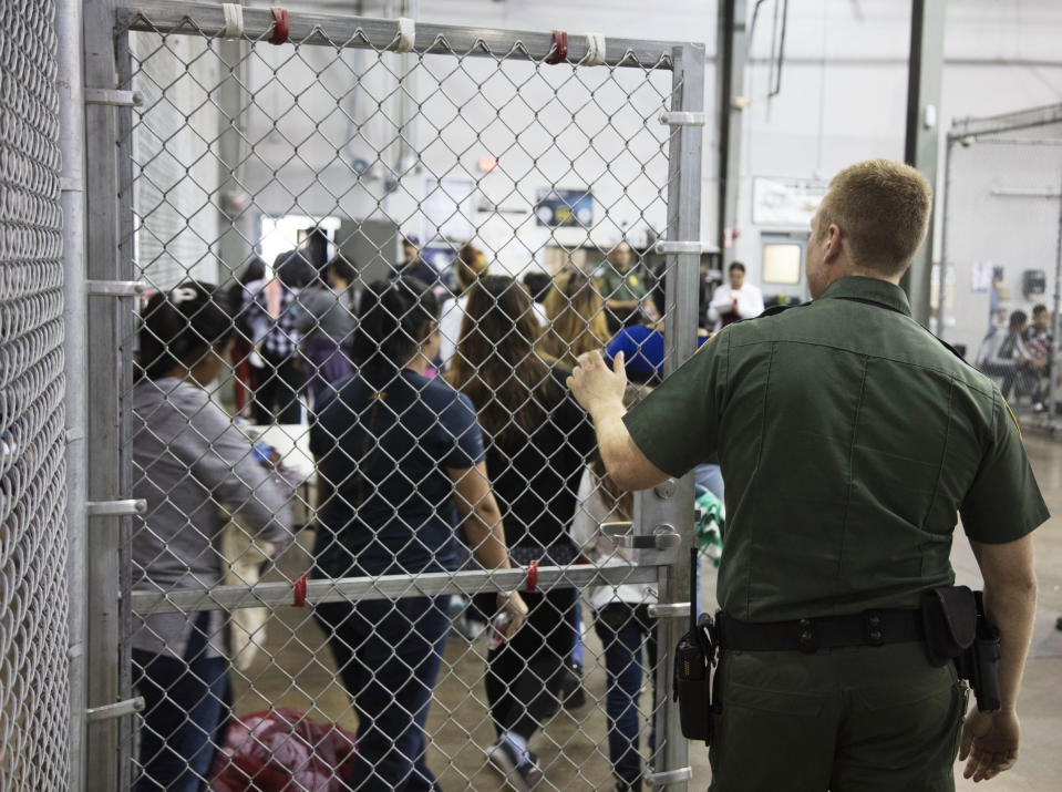 <p>A U.S. Border Patrol agent watches as people who’ve been taken into custody related to cases of illegal entry into the United States, stand in line at a facility in McAllen, Texas, Sunday, June 17, 2018. (Photo: U.S. Customs and Border Protection’s Rio Grande Valley Sector via AP) </p>