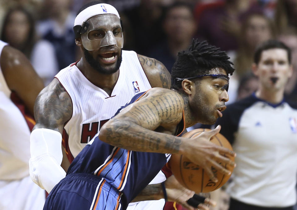 Miami Heat's LeBron James, left, blocks Charlotte Bobcats' Chris Douglas-Robert (55) during the second half of an NBA basketball game in Miami, Monday, March 3, 2014. LeBron James scored a team recond of 61 points. The Heat won 124-107. (AP Photo/J Pat Carter)