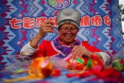 Photo taken on April 13, 2024, shows a villager of Yanglin Village is making Chinese perfume pouch. (Photo by Shi Yu)