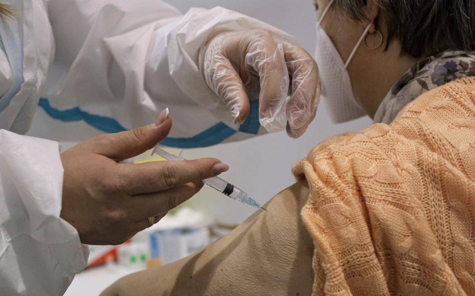 A woman receives a dose of the Chinese Sinopharm vaccine as country begins mass vaccination for the coronavirus - Marko Djurica/Reuters