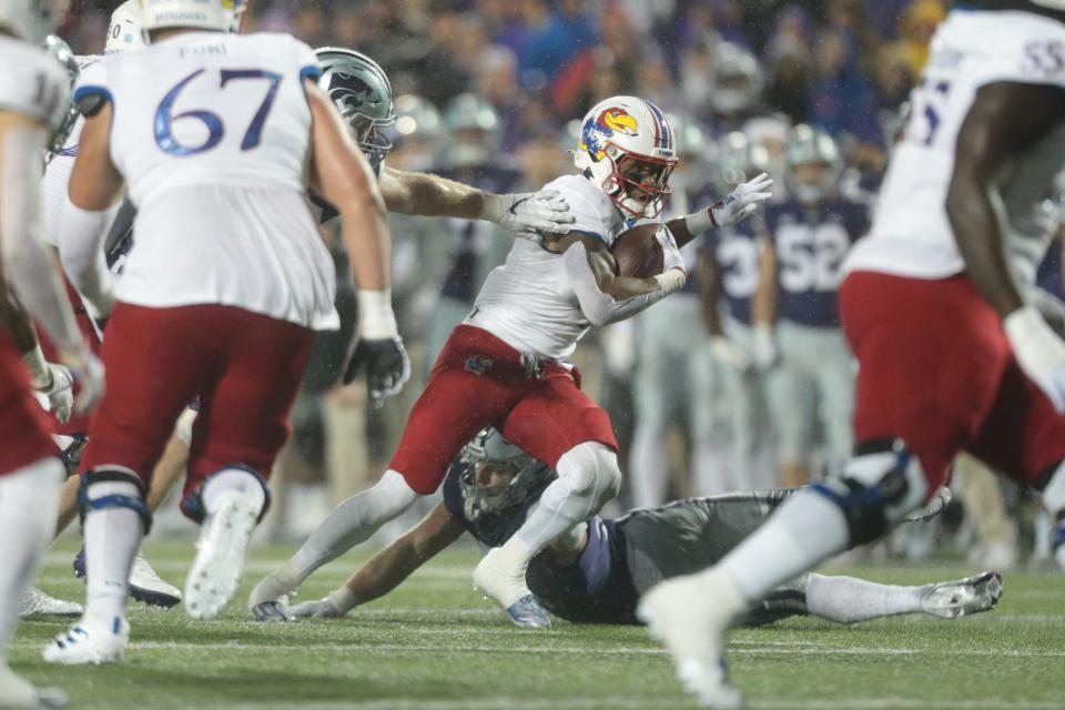 Kansas sophomore running back Devin Neal (4) maneuvers through the Kansas State defense to gain a first down in the second quarter of the Sunflower Showdown at Bill Snyder Family Stadium on Nov. 26.