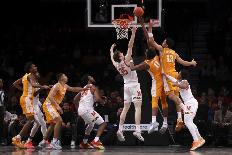 Maryland center Caelum Swanton-Rodger (35), Tennessee forward Tobe Awaka (11) and Tennessee forward Olivier Nkamhoua (13) jump for the ball during the first half of an NCAA college basketball game in the Basketball Hall of Fame Invitational, Sunday, Dec. 11, 2022, in New York. (AP Photo/Julia Nikhinson)