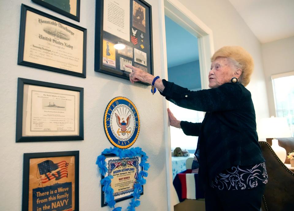 Mary German, whose 100th birthday will be celebrated with a Friday dance at the VFW in Palm Coast, shows her military mementos to guests in her apartment. "I loved my country and I wanted to do something for it,” she said.