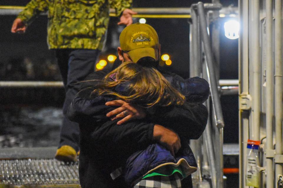 A sailor on the Oklahoma City greets his daughter after stepping onto dry land.