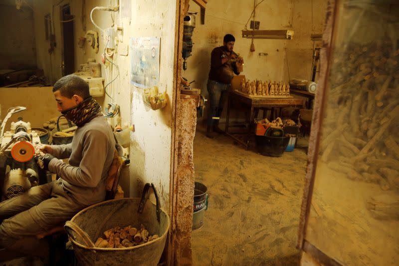 Palestinian workers carve figurines for sale during Christmas season, at a workshop in Bethlehem in the Israeli-occupied West Bank