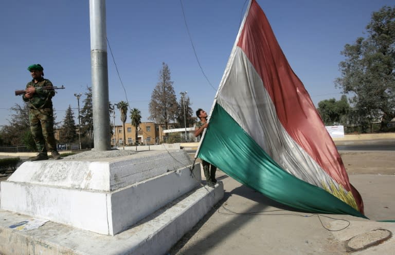 Iraqi forces remove a Kurdish flag as they advance towards the centre of Kirkuk on October 16, 2017 during an operation to oust Kurdish forces from disputed areas