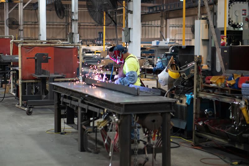 Julio Ventura welds a screed bottom for a commercial class road paver at the Calder Brothers factory in Taylors