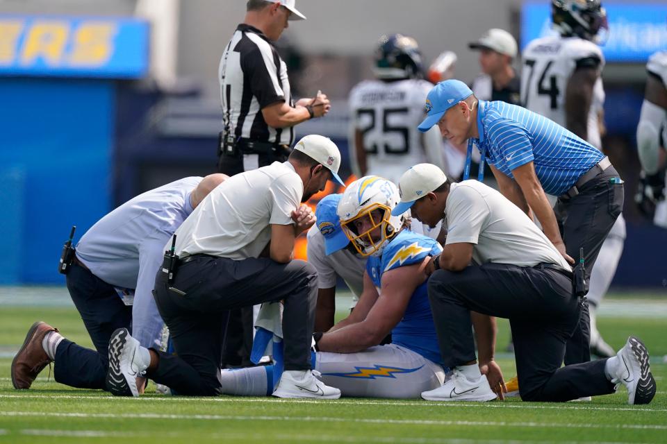Los Angeles Chargers linebacker Joey Bosa, middle, is checked on by trainers during the first half against the Jacksonville Jaguars.