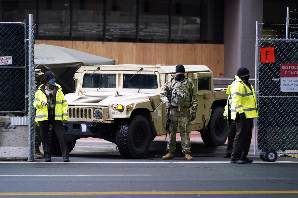 A National Guard soldier stands guard with deputies at the restricted vehicle entrance of the building where the Chauvin trial is being held. (Jim Mone/AP)