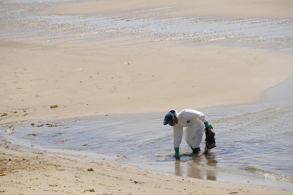 Workers carry out a cleanup operation on Mae Ramphueng Beach after a pipeline oil spill off the coast of Rayong province in eastern Thailand, Sunday, Jan. 30, 2022. Some 20-50 tons of oil are estimated to have leaked Tuesday night in the Gulf of Thailand from an undersea hose used to load tankers at an offshore mooring point owned by the Star Petroleum Refining Co. (AP Photo/Sakchai Lalit)