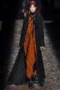 <p>A model wears an orange bandana-print maxi dress with long black coat at the Coach Fall 2018 show. (Photo: Getty) </p>