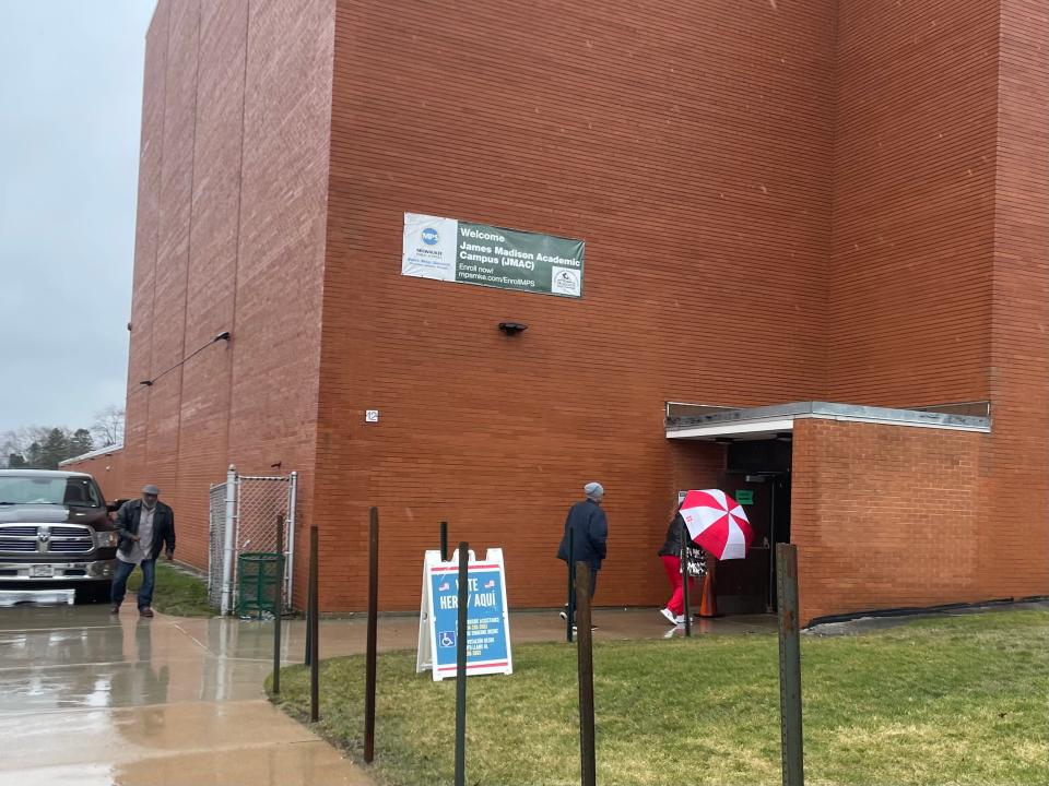 Voters brain rainy weather at James Madison Academic Campus in Milwaukee