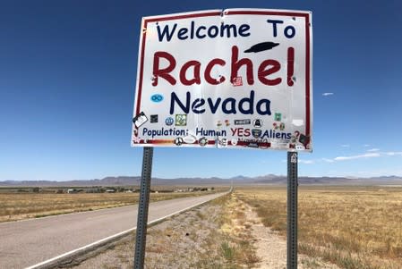 A sign reading "Welcome to Rachel Nevada" stands along the road in Rachel, Nevada