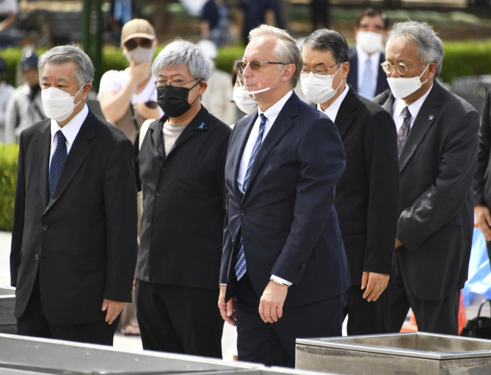 Russian Ambassador to Japan Mikhail Galuzin, center, visits the Peace Memorial Park in Hiroshima, western Japan, Thursday, Aug. 4, 2022. Russia and its ally Belarus were not invited to this year's peace memorial. Russian Ambassador to Japan Galuzin on Thursday offered flowers at a memorial epitaph in the park and told reporters his country would never use nuclear weapons. (Shingo Nishizume/Kyodo News via AP)
