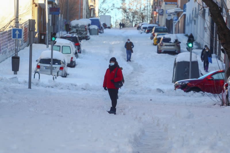 Una mujer de pie en una calle cubierta de nieve después de una fuerte nevada en Madrid, España, el 11 de enero de 2021