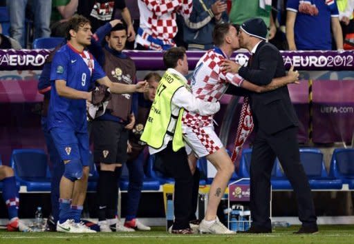 A pitch invader kisses Croatian head coach Slaven Bilic during the Euro 2012 championships football match Republic of Ireland vs Croatia at the Municipal Stadium in Poznan. Croatia won 3 to 1