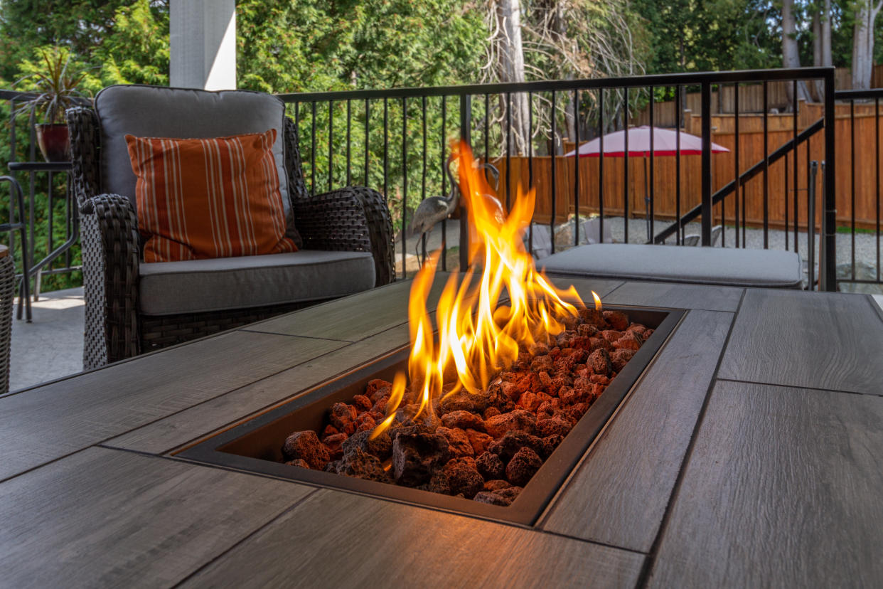 A spacious deck with a close up shot of a fire pit table heater: amazon fire pit