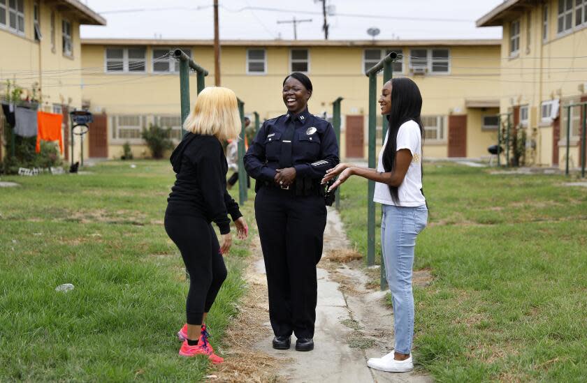 LOS ANGELES-CA-JULY 23, 2020: Emada Tingirides, center, chats with Petra Avelar, 18, left, and Meah Watson, 18, right, at Nickerson Gardens in Watts on Thursday, July 23, 2020. Avelar and Watson are best friends who grew up together in Nickerson Gardens and through Operation Progress will be attending college on the east coast this Fall. A community policing program known as Community Safety Partnership will now have its own bureau within the LAPD, headed by Emada Tingirides, whom will become the LAPD's second Black female deputy chief.(Christina House / Los Angeles Times)