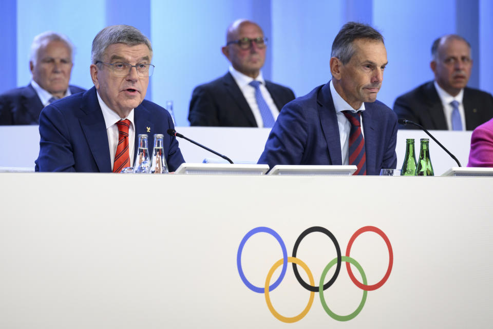 International Olympic Committee (IOC) President Thomas Bach, left, speaks next to IOC Director General Christophe de Kepper, right, at the opening of the hybrid 140th IOC Session of the International Olympic Committee (IOC), at the Olympic House, in Lausanne, Switzerland, Thursday, June 22, 2023. (Laurent Gillieron/Keystone via AP)