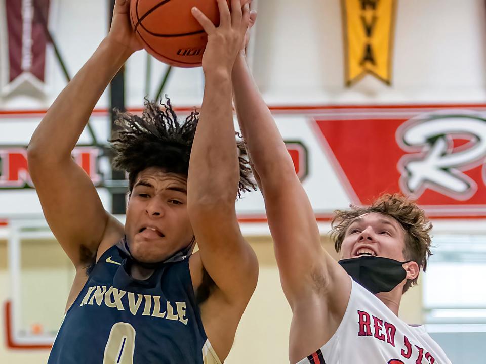 Knoxville High School junior Braden Downs, left, grabs a rebound away from United senior Colin Jenks during the Blue Bullets' 67-63 win over the Red Storm on Friday, Jan. 7, 2022 in rural Monmouth.