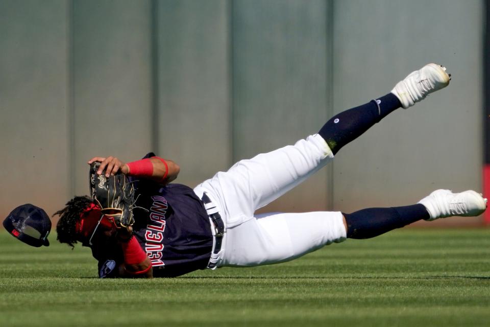 Cleveland Guardians non-roster invitee outfielder Oscar Gonzalez (90) completes a catch during a spring training baseball game against the Cincinnati Reds, Friday, March 18, 2022, at Goodyear Ballpark Goodyear, Ariz.