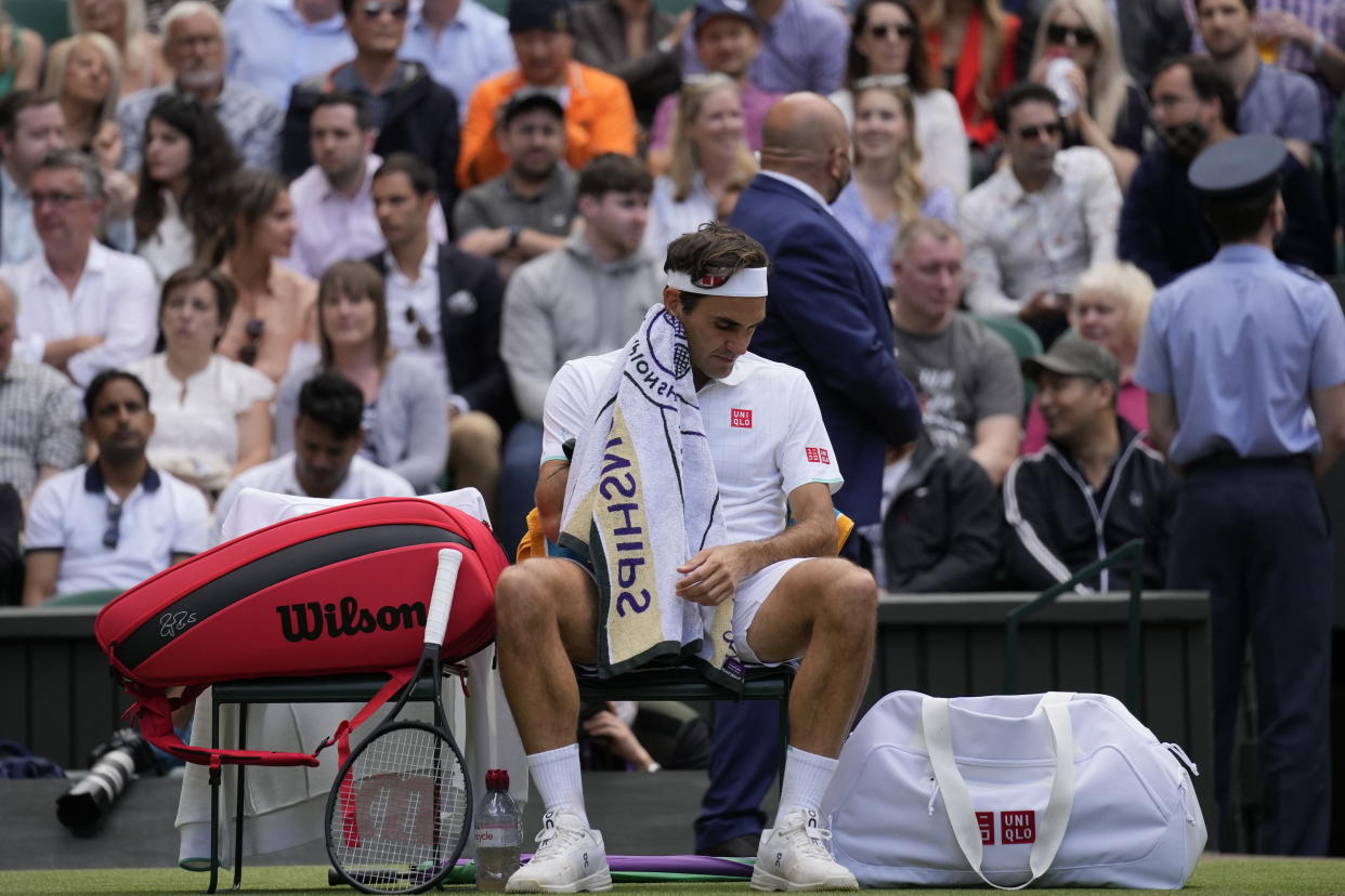 Switzerland's Roger Federer wipes his face with a towel during the men's singles quarterfinals match against Poland's Hubert Hurkacz on day nine of the Wimbledon Tennis Championships in London, Wednesday, July 7, 2021. (AP Photo/Kirsty Wigglesworth)