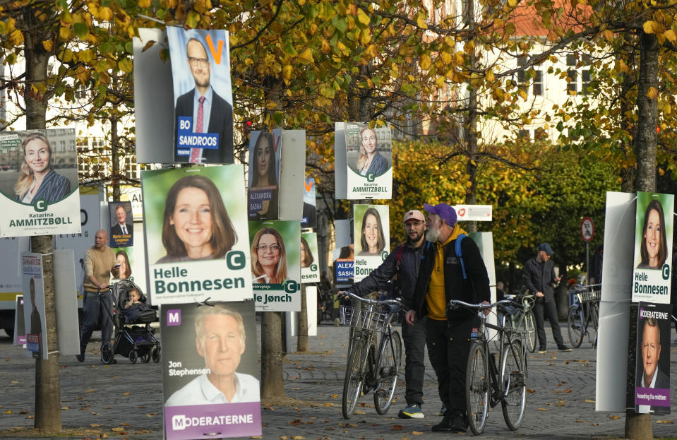 People pass by election campaign posters in Copenhagen, Denmark, Sunday, Oct. 30, 2022, ahead of the general election scheduled for Nov. 1, 2022. Denmark's election on Tuesday is expected to change its political landscape, with new parties hoping to enter parliament and others seeing their support dwindle. A former prime minister who left his party to create a new one this year could end up as a kingmaker, with his votes being needed to form a new government. (AP Photo/Sergei Grits)