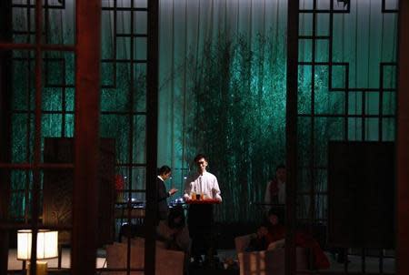 A waiter holds a drinks tray in a make-shift hotel lobby during the official launch of InterContinental Hotels Group's (IHG) new hotel brand called Hualuxe Hotels and Resorts, held inside the Forbidden City in Beijing March 19, 2012. REUTERS/David Gray