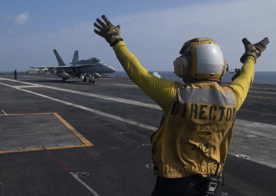 In this photo released by the U.S. Navy, Aviation Boatswain's Mate 3rd Class Marnell Maglasang, from La Puente, Calif., directs an F/A-18E Super Hornet on the flight deck of the aircraft carrier USS Nimitz in the Arabian Sea, Friday Nov. 27, 2020. The Nimitz returned to the Mideast in a move to support the drawdown of troops in Afghanistan and Iraq according to the Pentagon. However, the Nimitz's announced arrival came after the killing of an Iranian scientist who founded the Islamic Republic's military nuclear program in the early 2000s. (Mass Communication Specialist 3rd Class Cheyenne Geletka/U.S. Navy via AP)