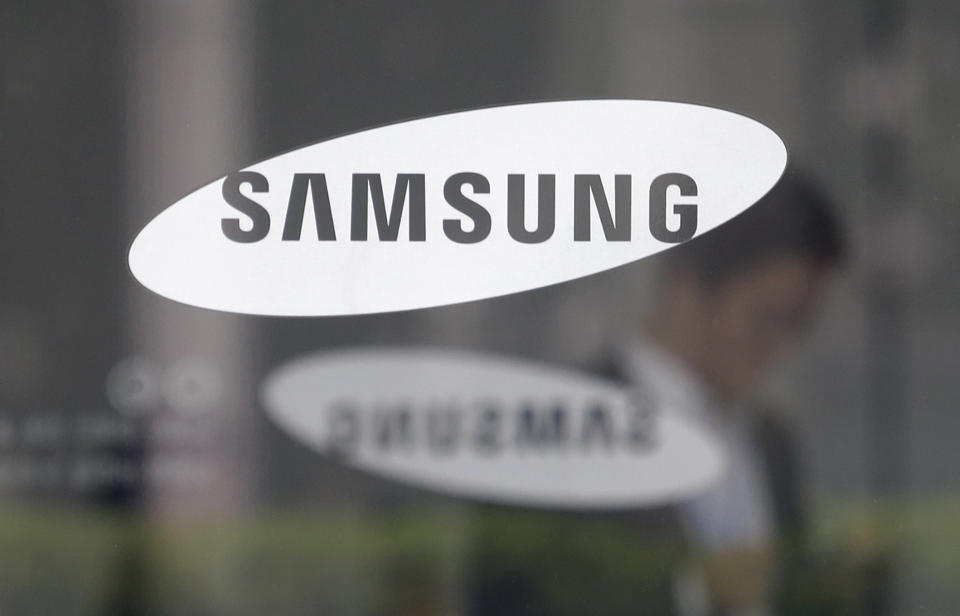 FILE - An employee walks past a logo of the Samsung Electronics Co. shown at its office in Seoul, South Korea. Samsung Electronics on Wednesday, July 26, 2023, unveiled two foldable smartphones as it continues to bet on devices with bending screens, a budding market that has yet to fully take off because of high prices. (AP Photo/Ahn Young-joon, File)