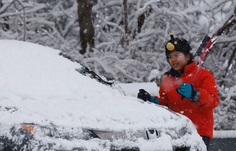 Un niño quita la nieve de un auto en Tappan, Nueva York