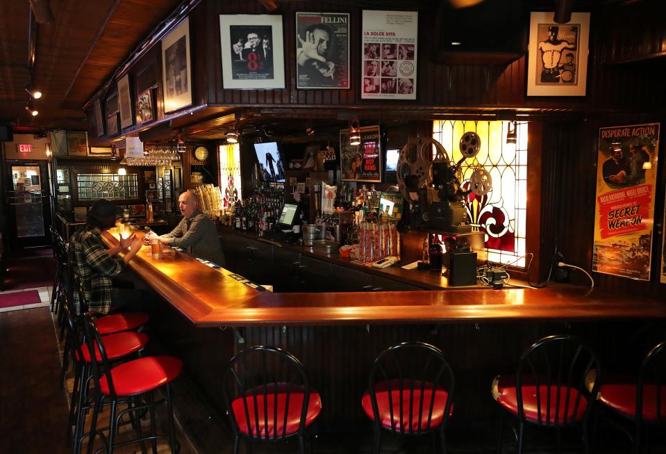 Alan Perella, owner of Larry's Main Entrance, chats with a customer at the Akron bar in October.