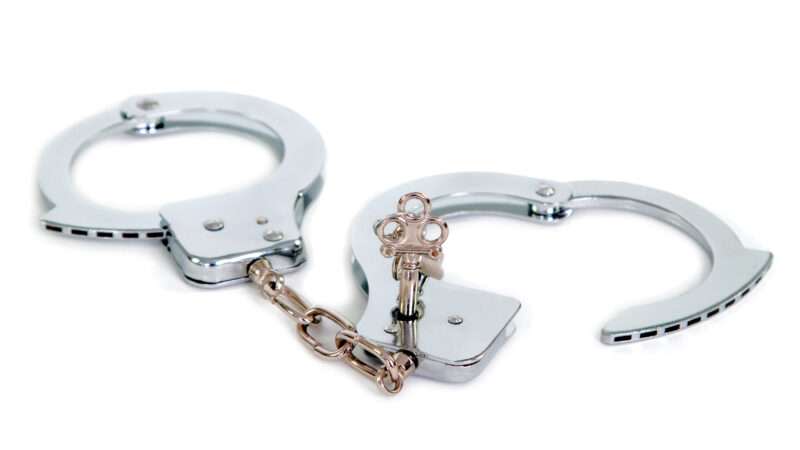Unlocked handcuffs against a white background.