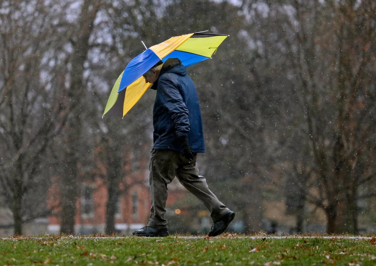 A Columbus resident takes a rainy walk through Schiller Park November 30, 2020.